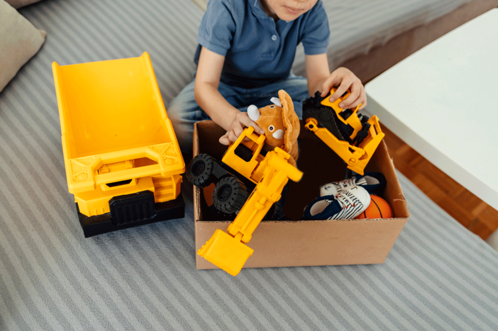 a boy looks at a box of toys