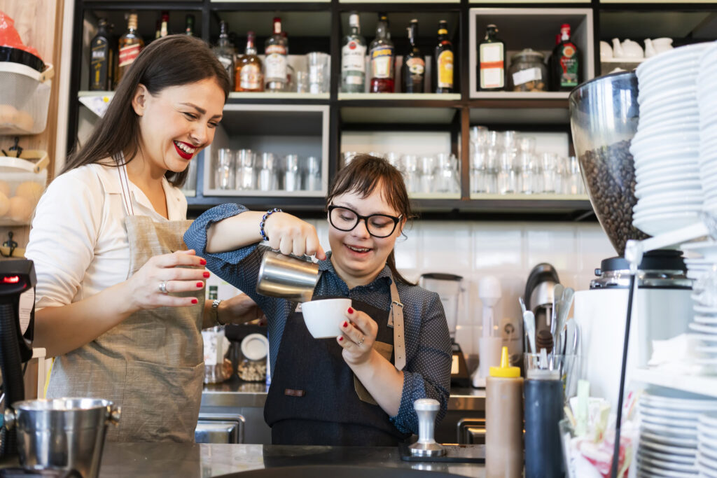 two baristas make a coffee one has mental disability
